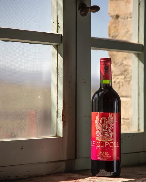 En flaska Le Cupole i ett fönster med utsikt över Val d’Orcia